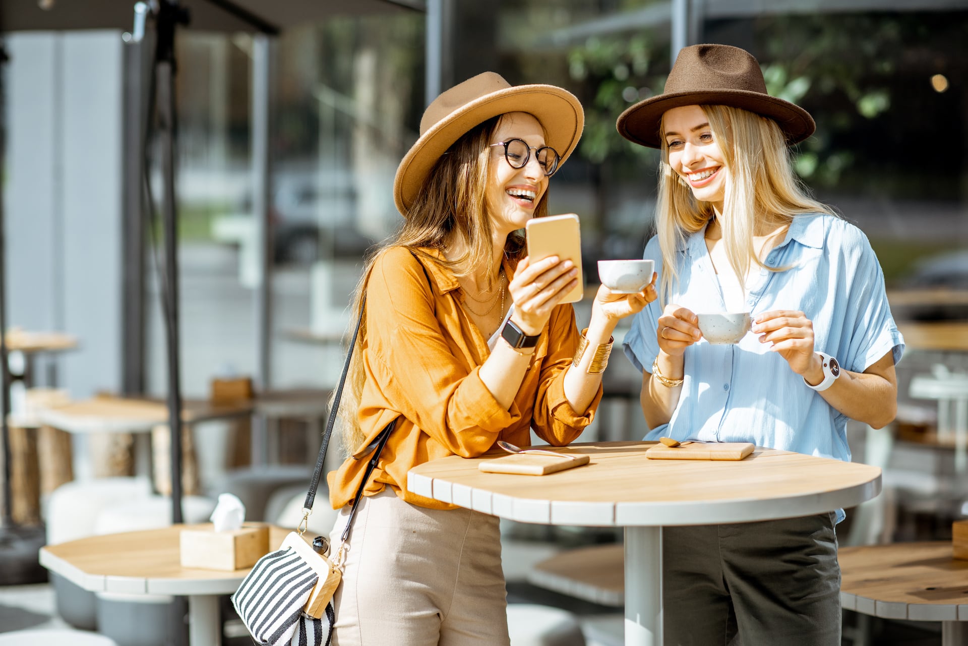 Two young women smiling at cafe
